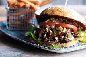 BBQ-Burger mit Röstzwiebeln, Tomate, Salat und Süßkartoffelpommes im Loft's Restaurant in Ingolstadt
