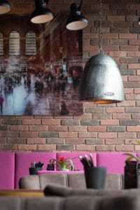 Innenaufnahme vom Loft’s Bar Bistro Steakhaus mit stimmungsvollem Licht, Kunst an der Wand und stylischen Möbeln.