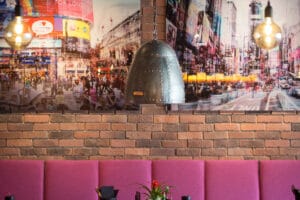 Urbanes Interieur mit New-York-Fotografie, Metalllampe und gepolsterten Sitznischen im Loft’s Restaurant in Ingolstadt.