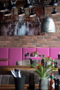 Design-Restaurant Loft’s in Ingolstadt mit industriellem Charme, Wandkunst und einladender Lounge-Ecke.