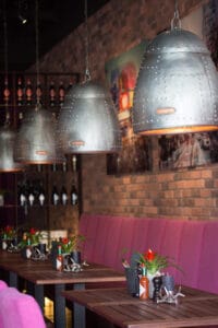 Gemütliche Restaurantatmosphäre mit Industrielampen, moderner Kunst und Holztischen im Loft’s Bar Bistro Ingolstadt.