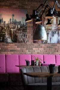Modernes Ambiente im Loft’s Bar Bistro Steakhaus Ingolstadt mit Backsteinwand, Ledersitzen und stimmungsvoller Beleuchtung.